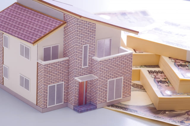 住宅模型と現金が並んでいる様子